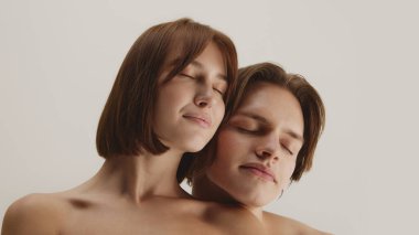 Gözleri kapalı bir çift, sakin bir rahatlama içinde birbirlerine yaslanıyorlar. Barış kavramı, iç denge, kendini kabullenme duygusal temelleri ve ruhsal berraklığı ifade eden.