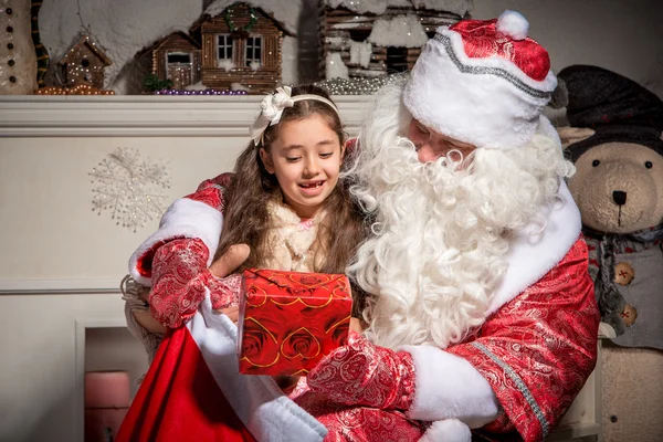 Conceito de férias e pessoas - menina sorridente com Papai Noel — Fotografia de Stock
