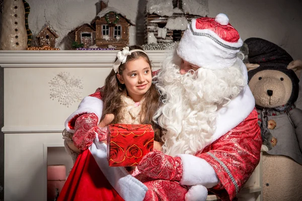 Conceito de férias e pessoas - menina sorridente com Papai Noel — Fotografia de Stock