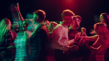 Yeni yıl partisi çifti kulüp dumanında konfetiyle dans ediyor. Tatil reklamları, alkol tanıtımları, şenlikli gece hayatı ve duygusal bağ kavramı.