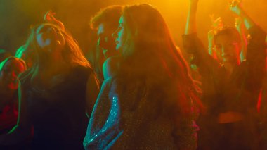 Noel kutlaması kalabalığı pırıl pırıl altın sisler içinde dans ediyor. Tatil pazarlama görselleri, gece hayatı coşkusu, moda yaşam tarzı ve sosyal markalaşma kavramı