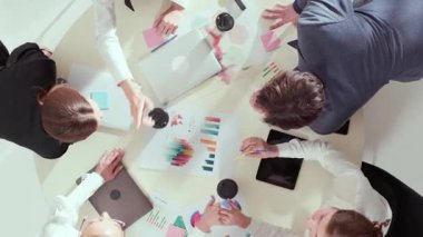 Yaratıcı toplantı sırasında çeşitli takımların çizelgelerle ve yapışkan notlarla çalışmalarının yukarıdan aşağı görüntüsü. Şirket ortamında yenilik, takım çalışması, üretkenlik ve ilham verici iletişim kavramı.