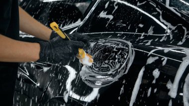 Tamirat sırasında arabanın yakıt deposunu köpükle temizleyen işçiler. Doğruluk kavramı, araba bakımı iş akışı, otomobil temizliği tanıtımı için ürün görselleri.