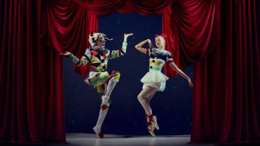 Oyuncu sahne anı. Pandomim ve balerin, tatil teması için renkli kıyafetler giyip poz veriyor. Eğlence, fantezi, karnaval, maskeli balo ve yaratıcı reklam anlayışı..