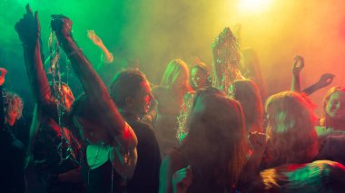 Yeni yıl partisi yeşil ve kehribar ışıklarıyla aydınlatılmış neşeli hareketlerle. Eğlence görselleri, duygusal gece hayatı, olay kutlamaları ve gençlik kültürü kavramı