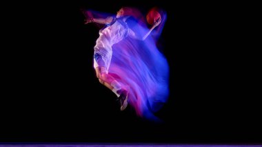 Basketbolcu, mor ve mavi neon hareketli topu ters tutarak zıplıyor. Sporcu hareketi, güç gelişimi, spor eğitimi ve spor farkındalığı kavramı.