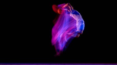 Basketbolcu topla zıplıyor ve dramatik hareket yakalama hareketinde mor ışık akışı var. Güç, spor kampanyası, spor motivasyonu ve atletik başarı kavramı..