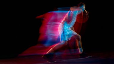 Basketbolcu topu ileri itiyor ve kırmızı ve mavi hareket çizgileri yaratıyor. Spor pazarlama, enerji akışı, hareket analizi ve fitness koordinasyonu kavramı.