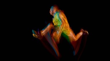 Sarı üniformalı basketbolcu renkli ışık hareketleriyle öne atlıyor. Atletik hareket analizi, performans eğitimi ve spor markalaşması kavramı.