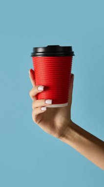 Marka tasarımı için mavi arka planda siyah kapaklı kırmızı kahve fincanı. İçecek ambalajı, kafe pazarlama, ürün modelleme ve perakende satış reklamları kavramı.