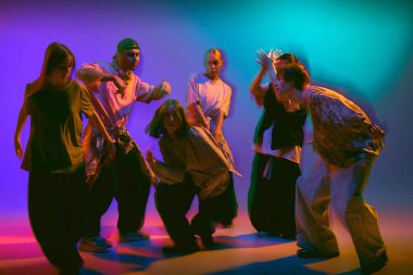 Sokak dansçıları hareket eden neon ışıklarıyla gösteri yapıyorlar. Gençlik enerjisi kavramı, moda kampanyası görselleri, kültürel performans ve yaşam tarzı tanıtımı için yaratıcı markalaşma.