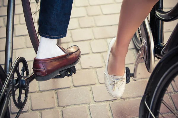 Jong koppel zittend op een fiets tegenover de stad — Stockfoto