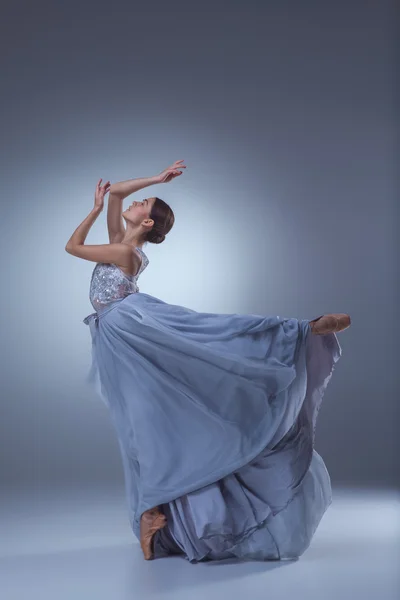 Krásná tanečnice tančí v modré dlouhé šaty — Stock fotografie