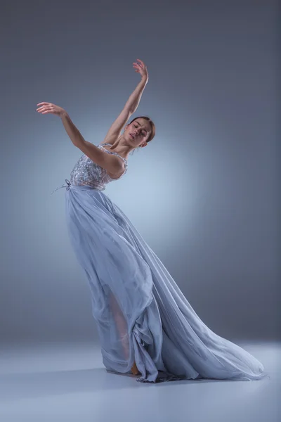 Красива балерина танцює в синій довгій сукні — стокове фото