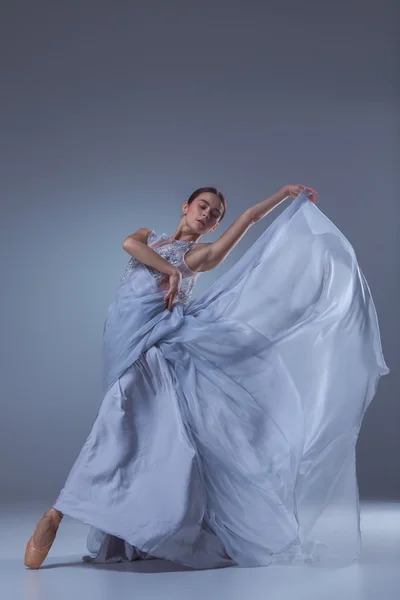Прекрасная балерина танцует в синем длинном платье — стоковое фото