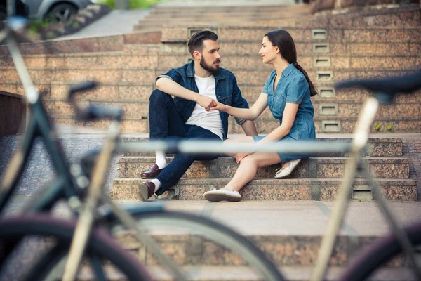 Jong koppel zitten tegenover een fiets — Stockfoto