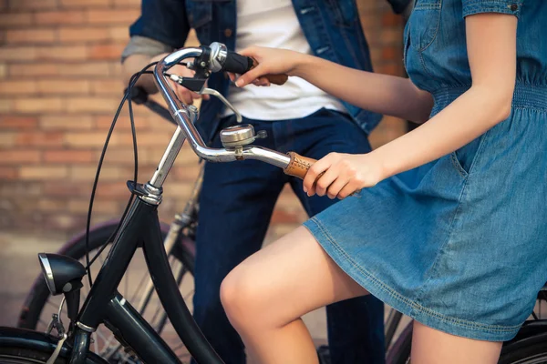 Jong koppel zittend op een fiets tegenover de stad — Stockfoto