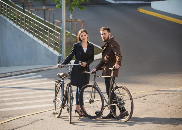 Молодая пара с велосипедом напротив города — стоковое фото