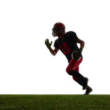 Sahada kararlı duygularla koşan Amerikalı futbolcu beyaz arka planda izole edildi. Spor faaliyeti kavramı, atlet terfisi, hareket halindeki vücut, fitness malzemeleri.