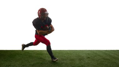 Amerikan futbol koşucusu güçlü bir kararlılıkla öne doğru koşuyor. Eğitim rehberi kavramı, spor uygulamaları, koçluk materyalleri, pazarlama görselleri, performans analizleri.