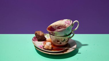 Çay küpleri ve çikolatalı çay fincanları istiflenmiş. Çay reklamcılığı, ambalaj, sofra takımı pazarlama, menü çizimleri ve dergi içeriği kavramı.