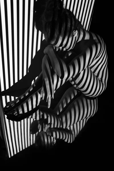 裸体的女人和她有黑色和白色斑马条纹的反射 创建与投影仪的黑白照片 — 图库照片