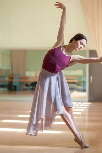 Ballerino classico che posa alla sbarra sullo sfondo della sala prove — Foto Stock