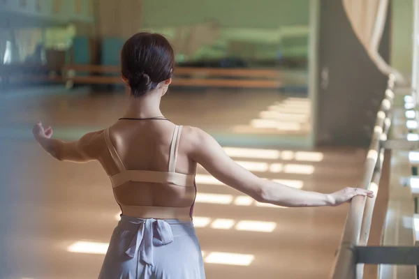 Klassieke balletdanser die zich voordeed op barre op repetitie kamer achtergrond — Stockfoto