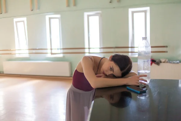 weary classic ballet dancer in rehearsal room background