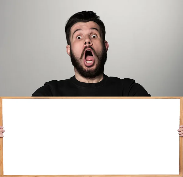 The surprised man and empty blank over gray background — Stock Photo, Image