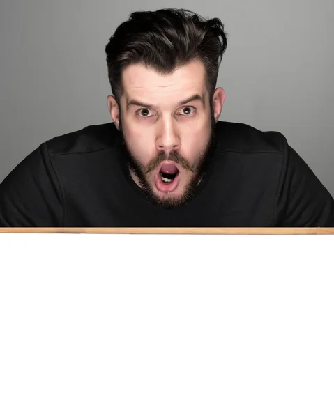 The surprised man and empty blank over gray background — Stock Photo, Image
