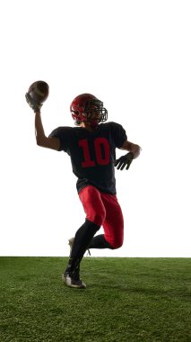 Dinamik fırlatma pozisyonunda Amerikalı futbolcu beyaz arka planda izole edilmiş güçlü duygularla poz veriyor. Spor hareketi kavramı, atlet medyası, koçluk materyalleri, reklamcılık.