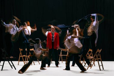 Hareket bulanıklığı olan insanlar, merkezdeki kırmızı figürün etrafında dönen ceketlerle cesur promosyon görselleri oluşturuyorlar. Yaratıcı pazarlama, görsel etki, marka ifadesi ve dinamik promosyon tasarımı kavramı.