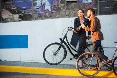 Genç çift bir bisiklet ile şehir karşısında