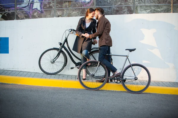 Młoda para z rower naprzeciwko miasta — Zdjęcie stockowe