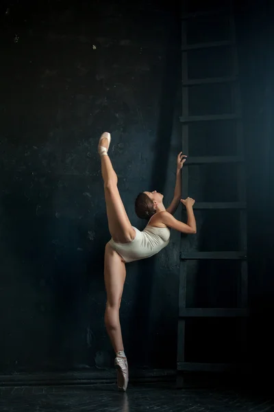 De prachtige ballerina poseren tegen donkere achtergrond — Stockfoto