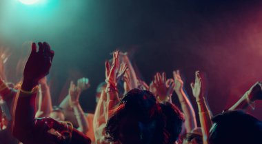 Gece kulübü kalabalığı renkli bir ışıkla kutluyor. Sosyal enerji kavramı, duygusal rahatlama, gece hayatı bağlantısı, müzik güdümlü hareket ve yeni yıl kaçamağı.