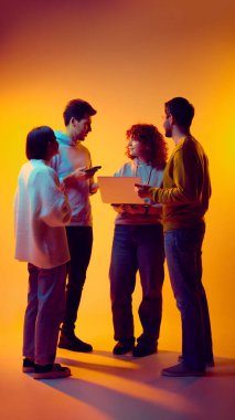 Ekip, dizüstü bilgisayar ve mobil cihazlar kullanarak proje görevlerini tartışıyor. İş birliği, çevik iş akışı, dijital iletişim, planlama toplantıları, başlangıç takım çalışması ve paylaşılan karar verme kavramı.