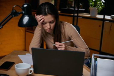 Kadın karar yorgunluğu çekerken verileri analiz ediyor. Analitik aşırı yükleme kavramı, bilişsel yorgunluk, profesyonel veri çalışma baskısı, düşük karar kalitesi.