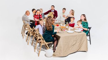 Geniş aile, çocuklar ve balonlarla şenlikli yemek masasının etrafında toplandı. Aile yaşam tarzı kavramı, süpermarket markalaşması, mevsimlik promosyonlar, ev kutlamaları görselleri ve perakende reklamları.