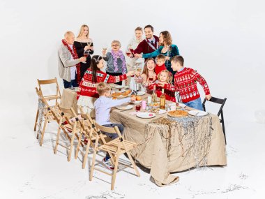 Çocuklar ve yetişkinlerin bayramları kutladığı şenlikli aile yemeği sahnesi. Yemek teslimatı görsel, aile yemeği pazarlaması, tatil menüsü tanıtımı ve mevsimsel hayat tarzı anlatımı kavramı.