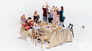 Aile tatilleri kutlarken fotoğraf çeker ve anlarını paylaşır. Sosyal medya reklamları, mobil yaşam tarzı görselleri, modern aile hikayeleri ve şenlikli dijital kampanyalar kavramı.