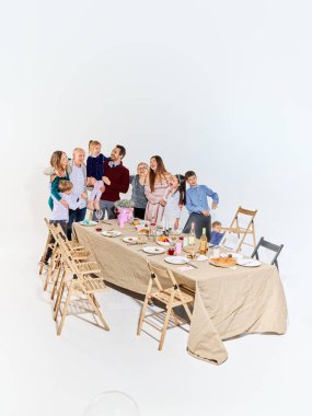 Çok nesilli sıcak aile ziyafetli yemek masasının etrafında toplanıyor. Yaşam tarzı reklamcılığı, ev yemeği markaları, aile değerleri pazarlama, duygusal hikaye anlatımı ve sosyal medya içeriği kavramı.