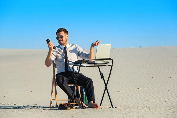 Homme d'affaires utilisant un ordinateur portable dans un désert — Photo
