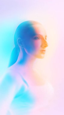 Renk eğimli ışıklandırmalı, yumuşak odak noktasında rüya gibi bir kadın portresi. Sağlık yaşam tarzı görselleri, cilt bakımı kampanyaları, kozmetik hikaye anlatımı ve rahatlamış duygusal durum kavramı..