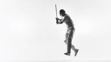 Cricket batsman mid air defensive batting technique in studio isolated. Concept of reaction training, defensive skill drills, athletic control and professional cricket education content.