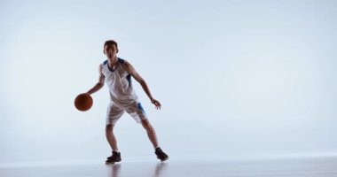 Basketbolcu, dinamik oyun sırasında topla yan yana zıplıyor. Patlayıcı hareket, atletik yaratıcılık, hızlı karar akışı ve modern spor ifadesi kavramı.