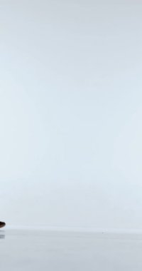 Basketbolcunun geniş duruşu topa odaklanmış şekilde vuruyor. Mesafe talimi, kontrol eğitimi, atletik disiplin ve temel top becerilerinin güçlendirilmesi kavramı.