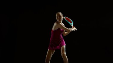 Profesyonel bayan tenisçi stüdyoda ters vuruş hazırlıyor. Tenis eğitimi içeriği, spor ekipmanları pazarlama, performans analizi ve atletik reklamcılık kavramı.