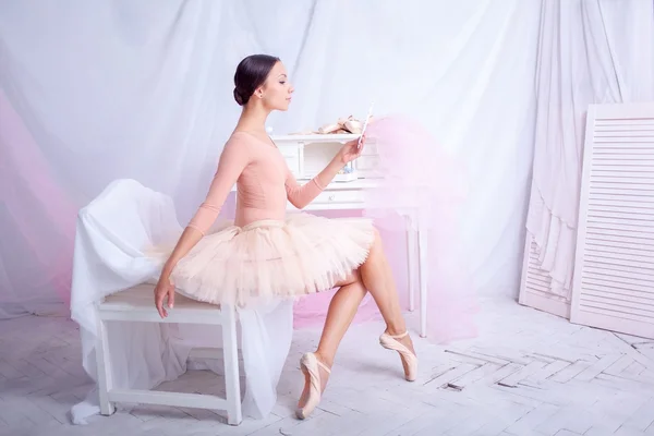 Professional ballet dancer looking in the mirror on pink — Stock Photo, Image